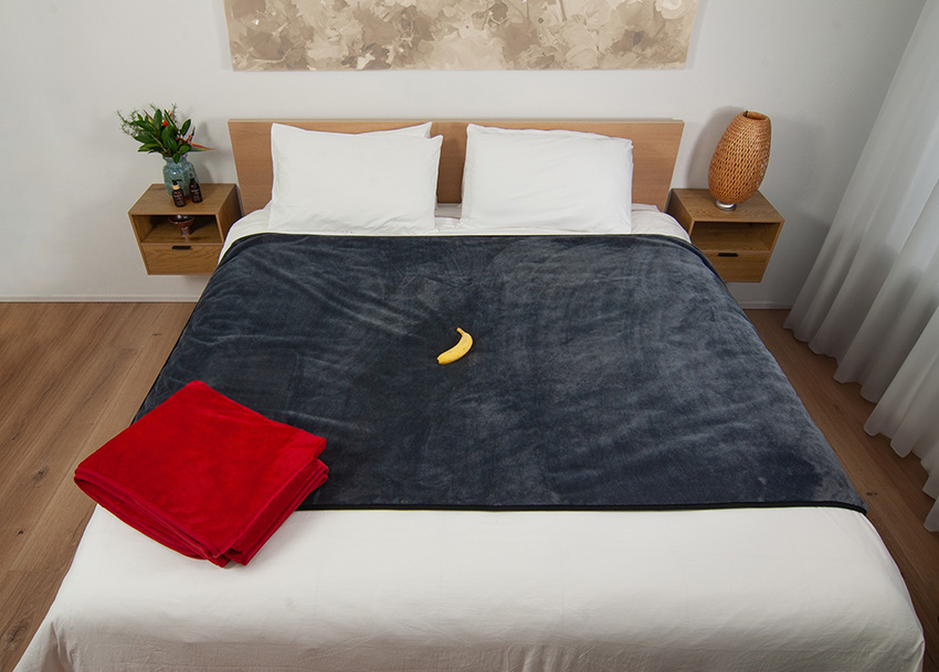 hero image of waterproof blanket draped on top of a king size bed